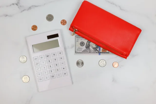Red wallet, coins, calculator on marble. Perfect for finance or business concepts. Project budgets and time tracking